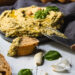 Basilikum Hummus in Schale und Baguette Brot