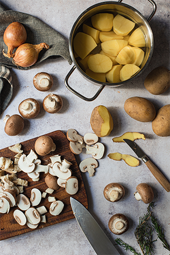 Pilze, Kartoffeln und Zwiebeln auf Küchenarbeitsplatte